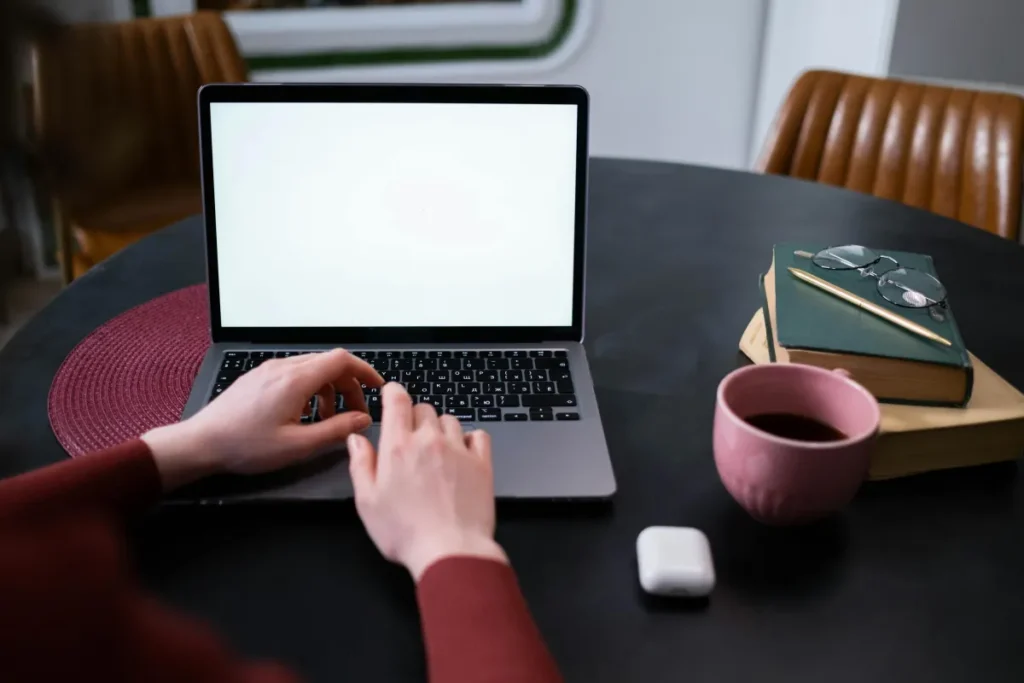 Tangan mengetik di laptop di ruang kerja rumah dengan koneksi internet untuk tes kecepatan